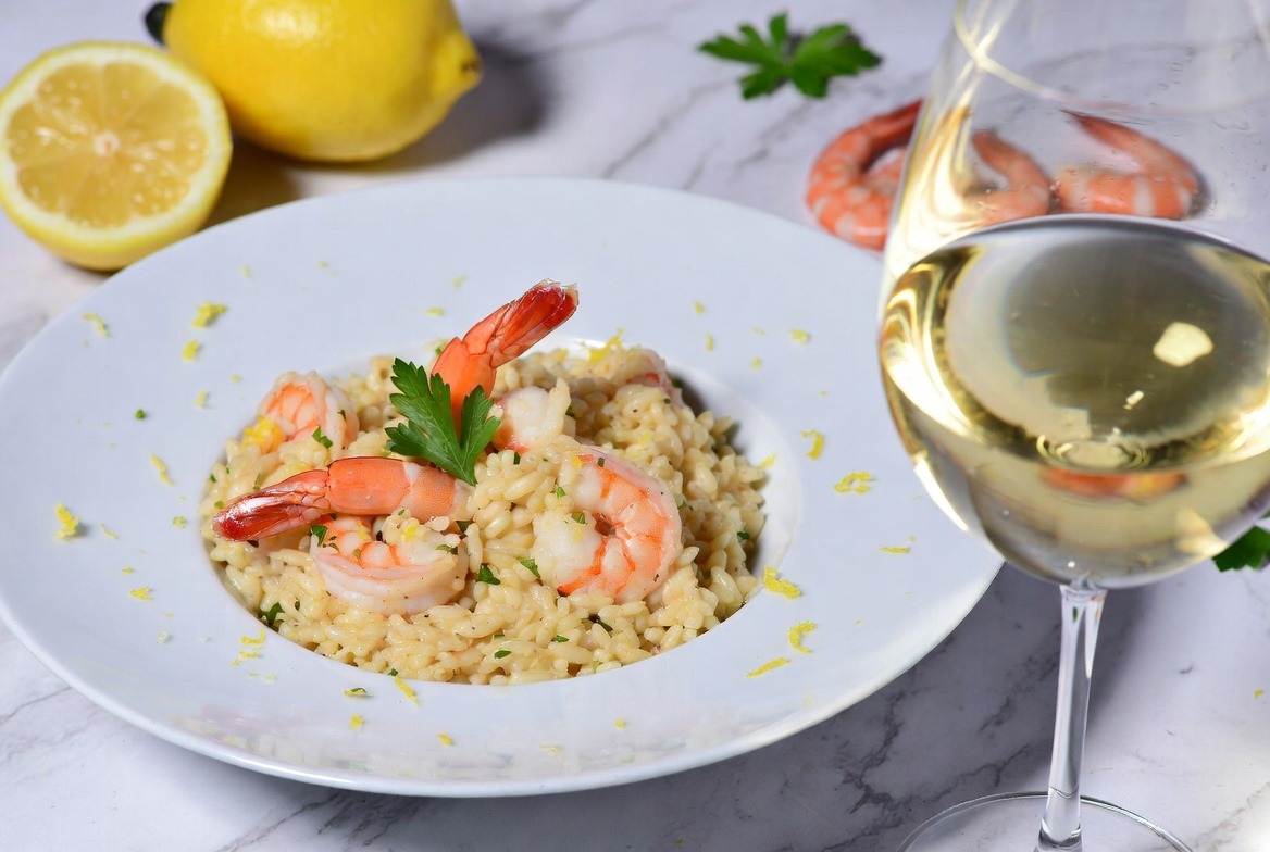 Risoto de camarão com limão siciliano harmonizado com taça de vinho branco gelado